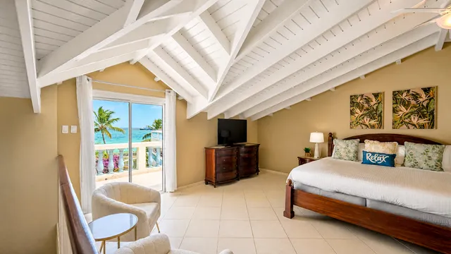 Top-floor bedroom with vaulted ceiling and beach view