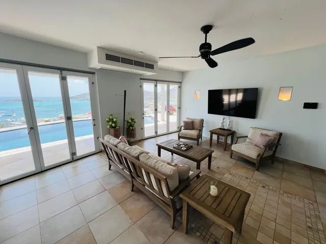 Living room opening onto the pool terrace with sea view